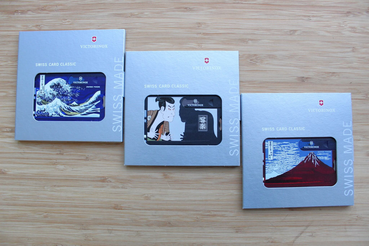 Set of three Victorinox Swiss Card Classic multi-tools featuring Japanese Ukiyo-e artwork: Red Fuji, The Great Wave, and Sharaku displayed together