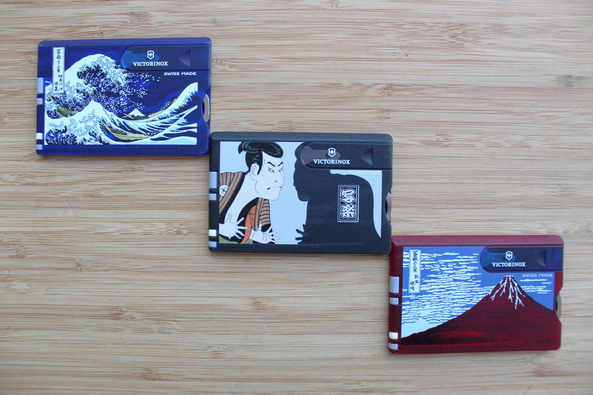 Set of three Victorinox Swiss Card Classic multi-tools featuring Japanese Ukiyo-e artwork: Red Fuji, The Great Wave, and Sharaku displayed together
